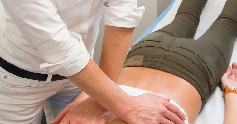 Dr. Isabell Winter behandelt eine liegende Patientin.