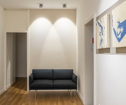 Wartebereich mit einem Sofa in der Praxis IsarOrthoCenter München