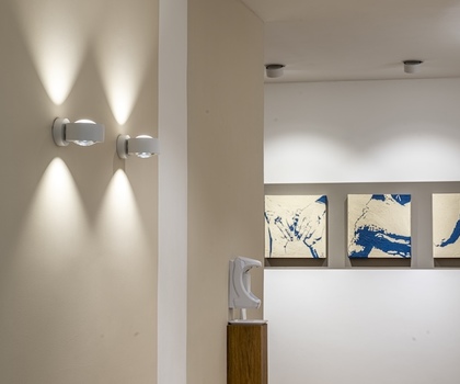 Nahaufnahme Flur mit Bildern und Lampen in der Praxis IsarOrthoCenter München